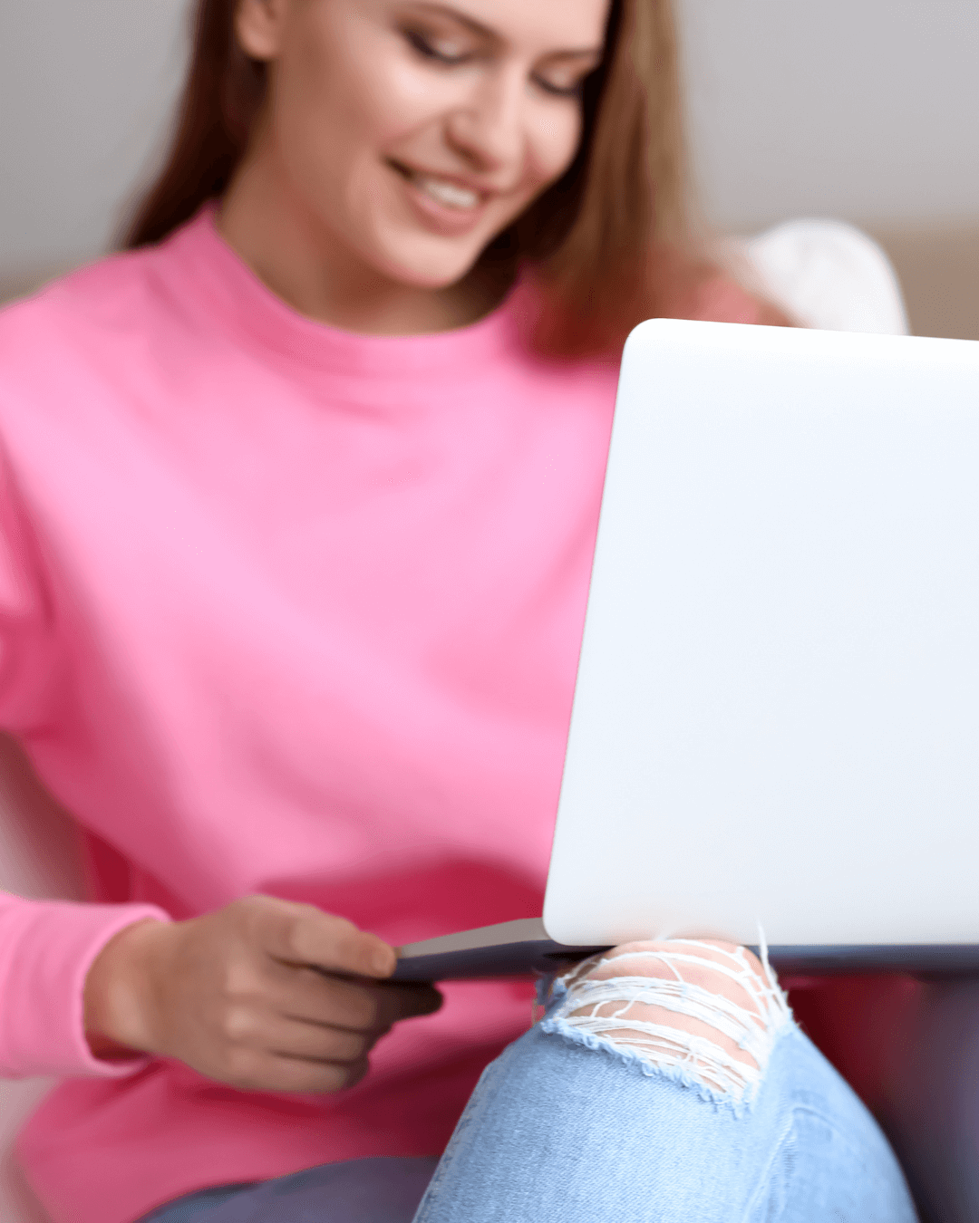 Woman in pink holding laptop