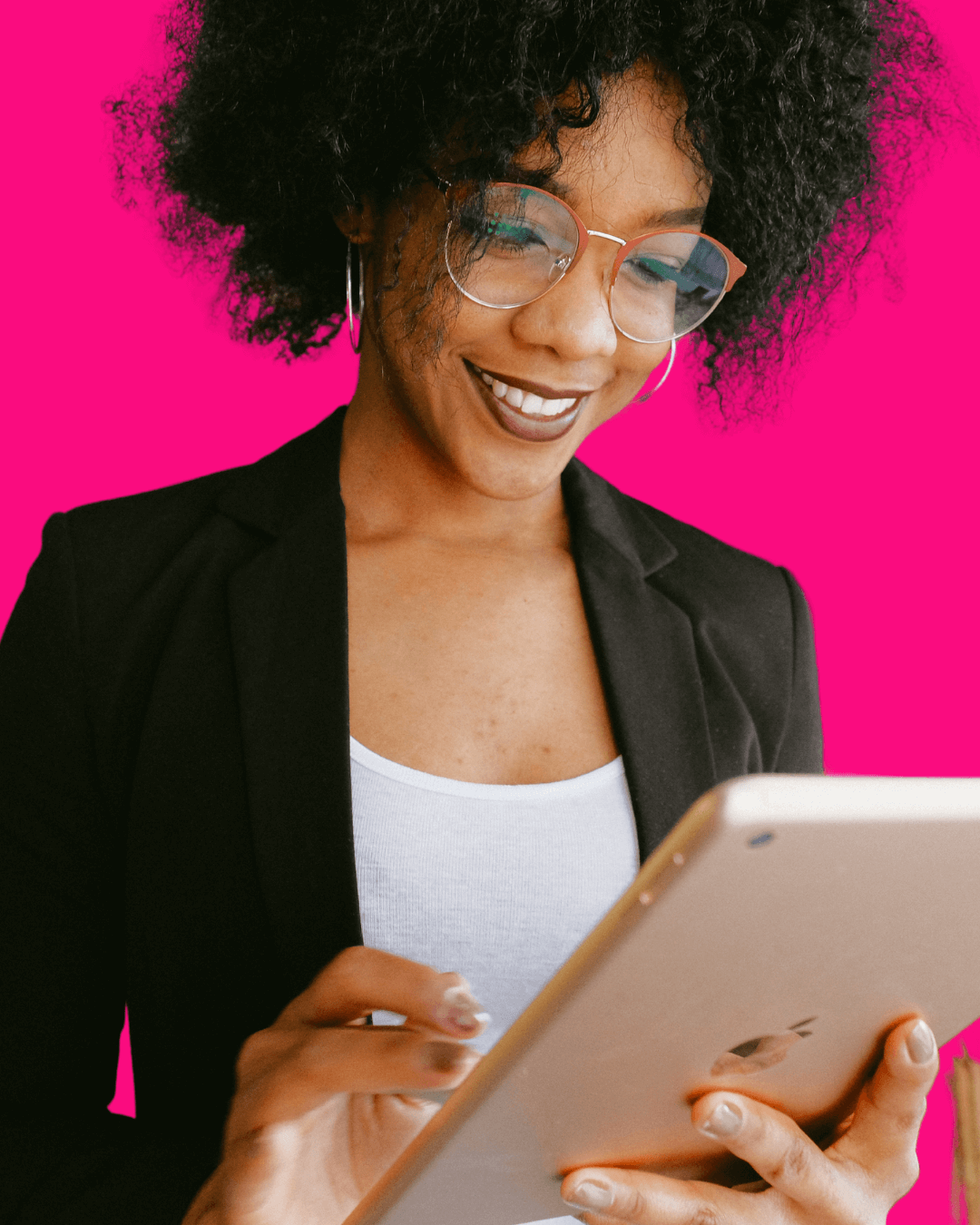 Woman wearing glasses in black suit jacket looking at ipad